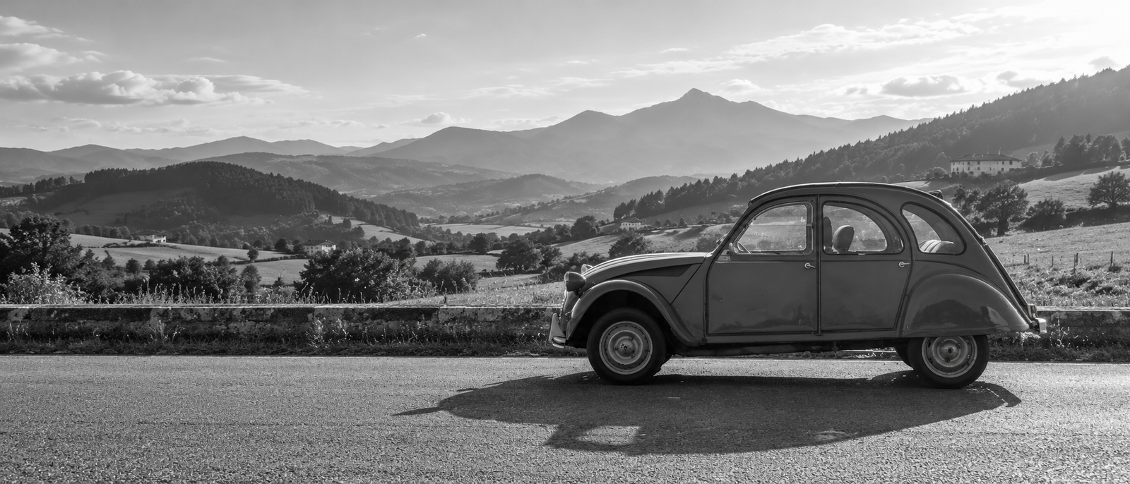 Citroën 2CV ante un paisaje de montañas